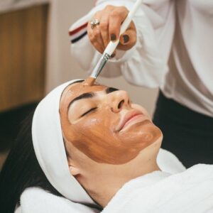 woman receiving facial mask treatment at spa